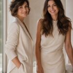 Ritratto editoriale di 2 donne 35-45 anni, in pose diverse tra loro, look diversi e vestiti diversi, sorridenti luce naturale laterale morbida, sfondo